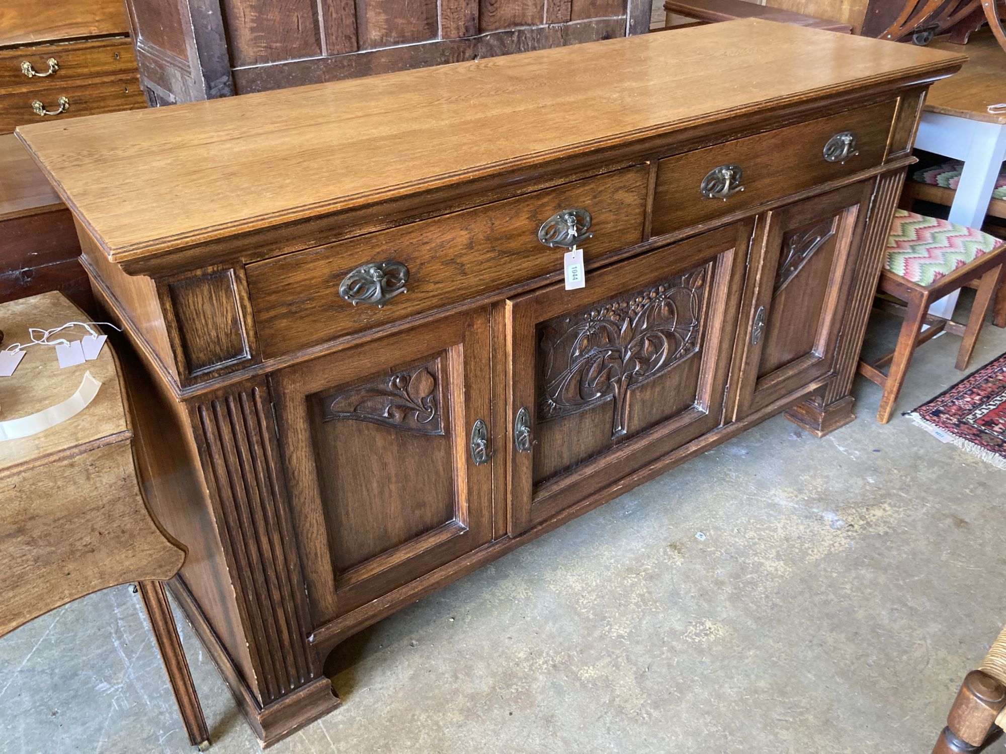 A late Victorian Art Nouveau carved oak sideboard, length 186cm, depth 62cm, height 102cm